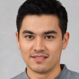 Joyful latino young-adult male with short  brown hair and brown eyes