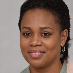 Joyful black young-adult female with long  brown hair and brown eyes