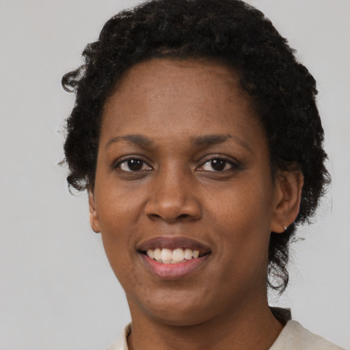 Joyful black adult female with short  black hair and brown eyes