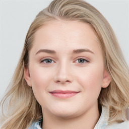 Joyful white young-adult female with long  brown hair and blue eyes