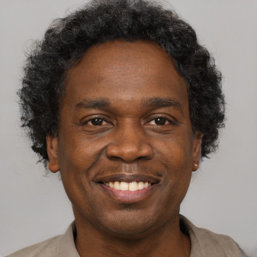 Joyful black adult male with short  brown hair and brown eyes