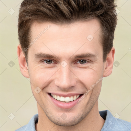 Joyful white young-adult male with short  brown hair and grey eyes