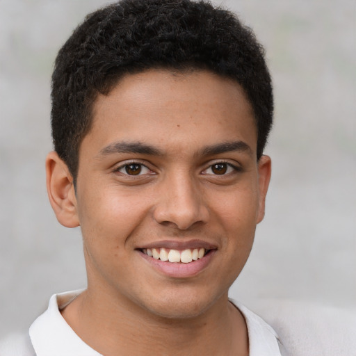 Joyful latino young-adult male with short  brown hair and brown eyes