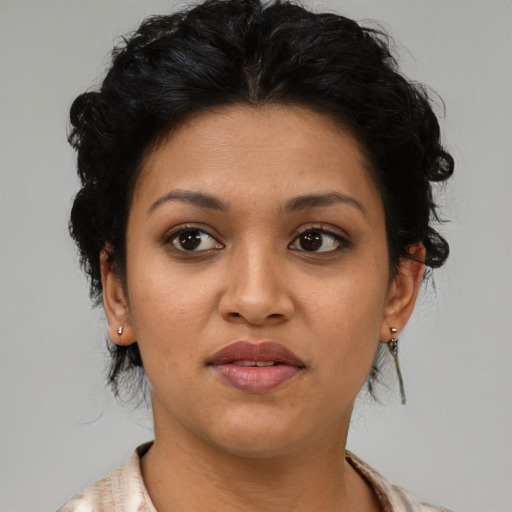 Joyful latino young-adult female with medium  brown hair and brown eyes