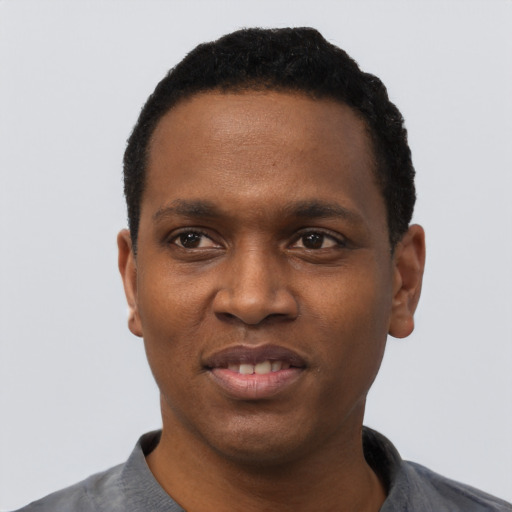 Joyful black young-adult male with short  black hair and brown eyes