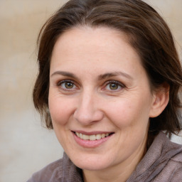 Joyful white adult female with medium  brown hair and grey eyes