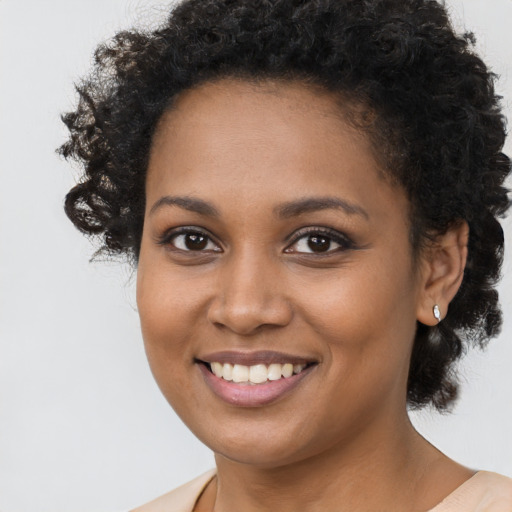 Joyful black young-adult female with short  brown hair and brown eyes