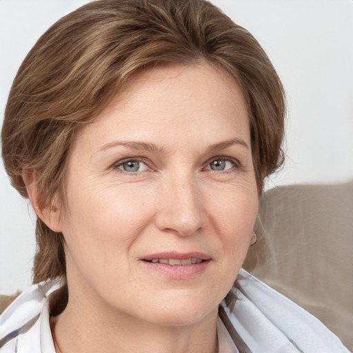 Joyful white adult female with medium  brown hair and blue eyes