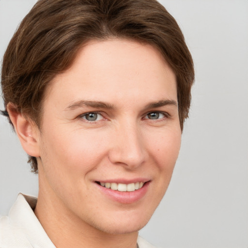 Joyful white young-adult female with short  brown hair and grey eyes