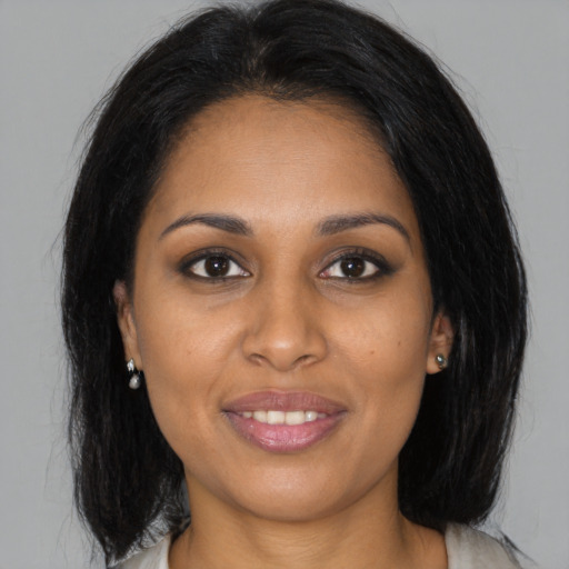 Joyful black young-adult female with medium  brown hair and brown eyes