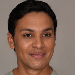 Joyful latino adult male with short  brown hair and brown eyes