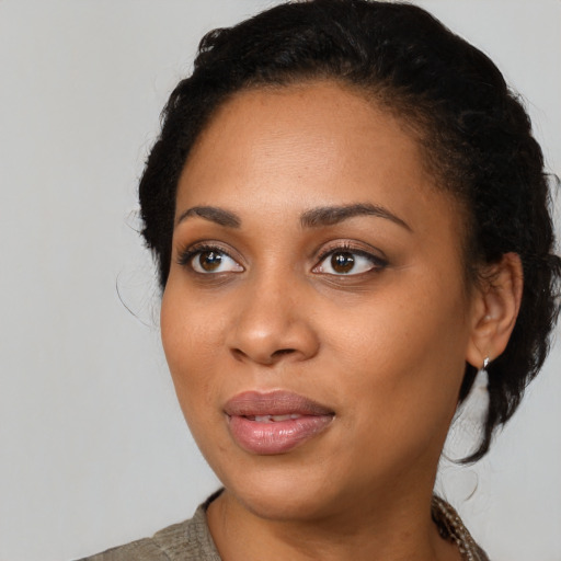 Joyful black young-adult female with medium  black hair and brown eyes