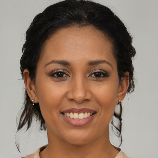 Joyful latino young-adult female with medium  brown hair and brown eyes