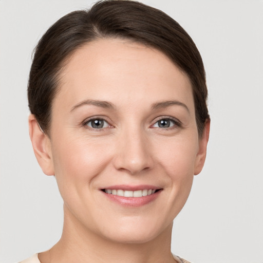 Joyful white young-adult female with short  brown hair and grey eyes