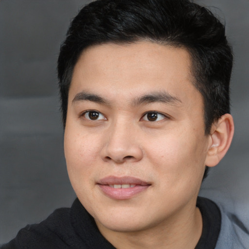 Joyful asian young-adult male with short  brown hair and brown eyes