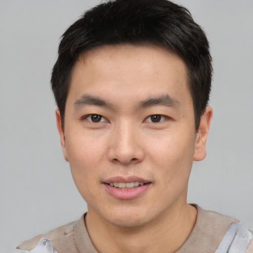 Joyful asian young-adult male with short  brown hair and brown eyes