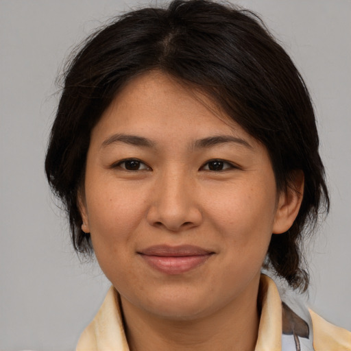 Joyful asian adult female with medium  brown hair and brown eyes