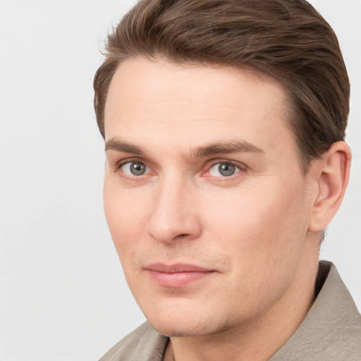 Joyful white young-adult male with short  brown hair and grey eyes