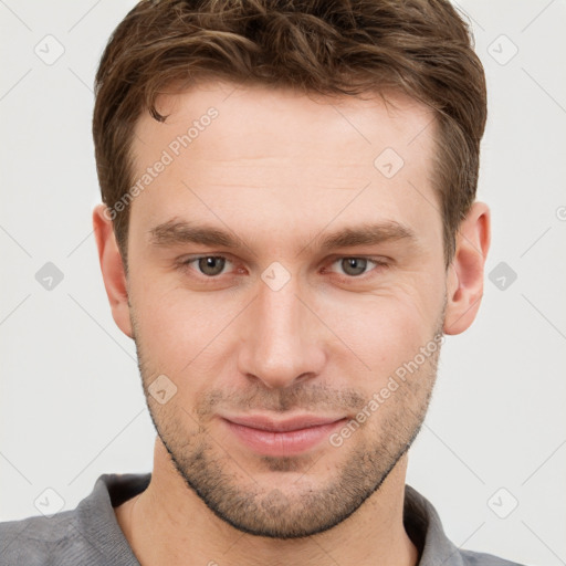 Joyful white young-adult male with short  brown hair and grey eyes