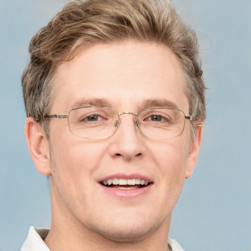 Joyful white adult male with short  brown hair and blue eyes