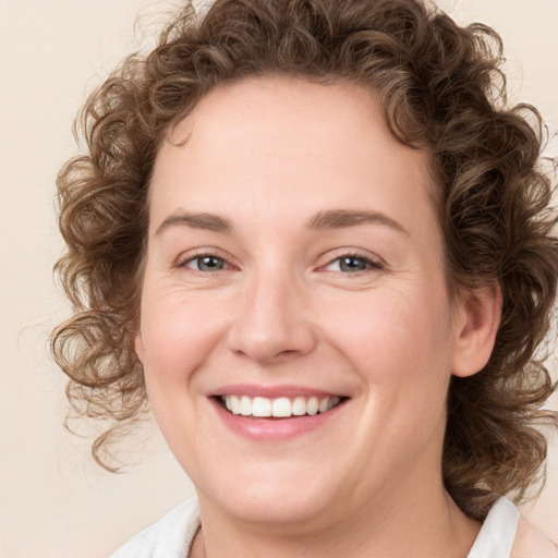 Joyful white young-adult female with medium  brown hair and blue eyes