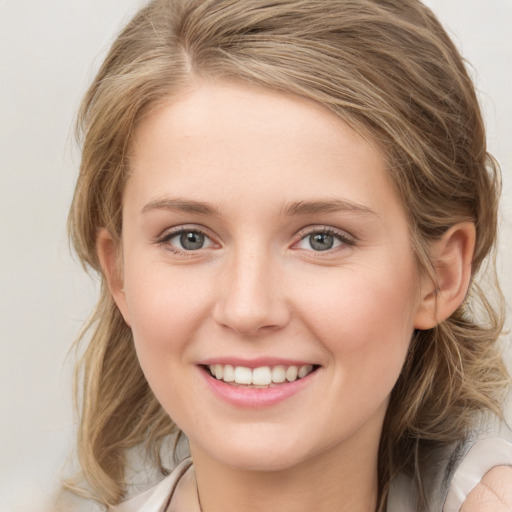 Joyful white young-adult female with medium  brown hair and blue eyes