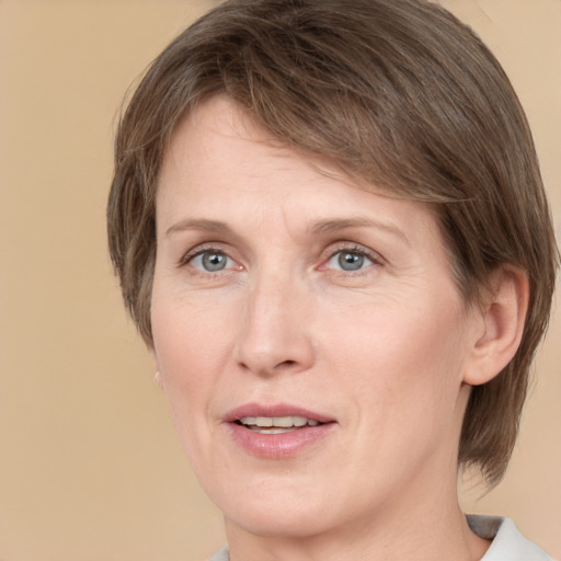 Joyful white adult female with medium  brown hair and grey eyes