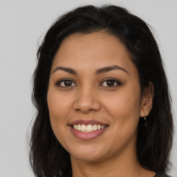 Joyful latino young-adult female with long  brown hair and brown eyes