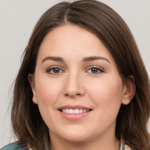 Joyful white young-adult female with medium  brown hair and grey eyes