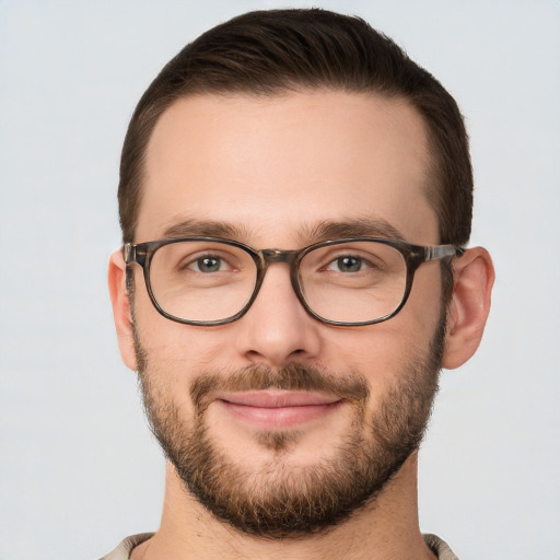 Joyful white young-adult male with short  brown hair and grey eyes