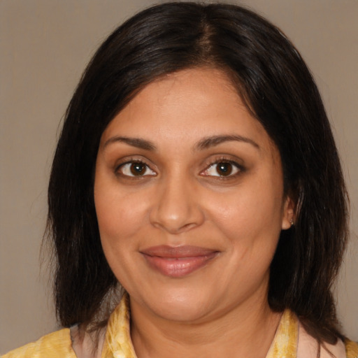 Joyful latino adult female with medium  brown hair and brown eyes