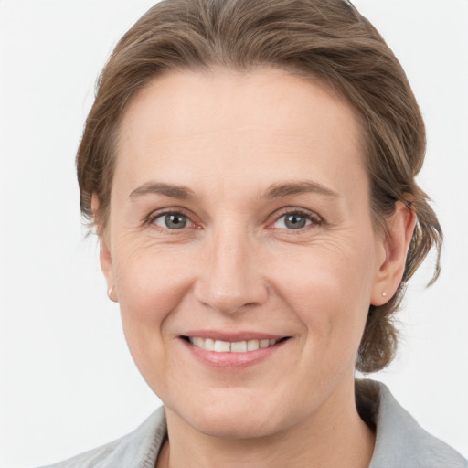 Joyful white young-adult female with medium  brown hair and grey eyes