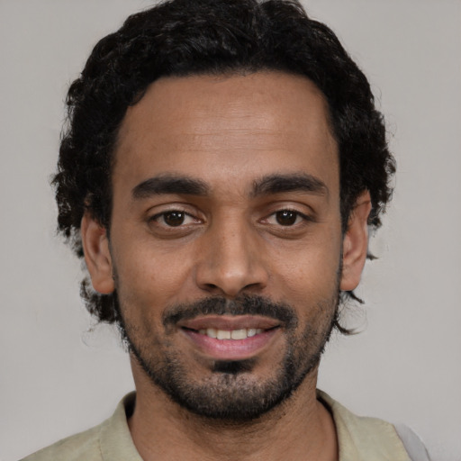 Joyful black young-adult male with short  black hair and brown eyes