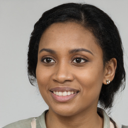 Joyful black young-adult female with long  black hair and brown eyes