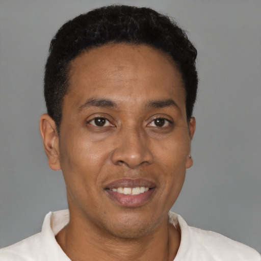 Joyful black adult male with short  brown hair and brown eyes