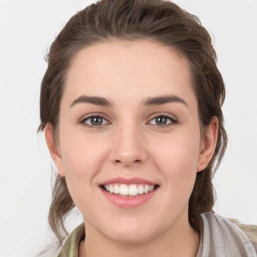 Joyful white young-adult female with medium  brown hair and grey eyes