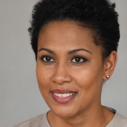 Joyful black young-adult female with short  brown hair and brown eyes