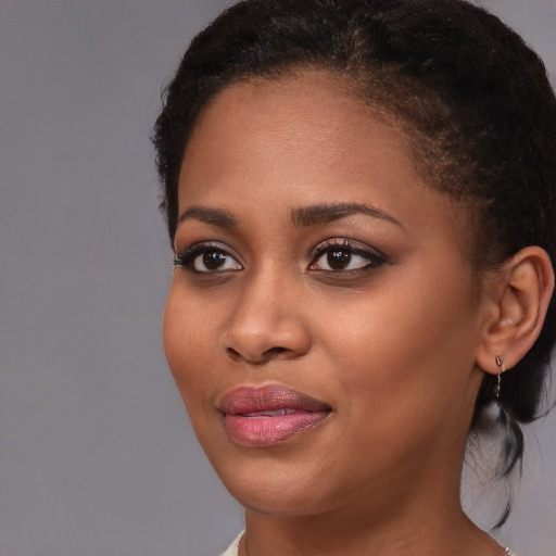 Joyful black young-adult female with medium  brown hair and brown eyes
