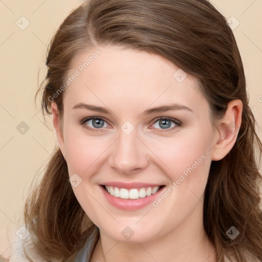 Joyful white young-adult female with long  brown hair and blue eyes