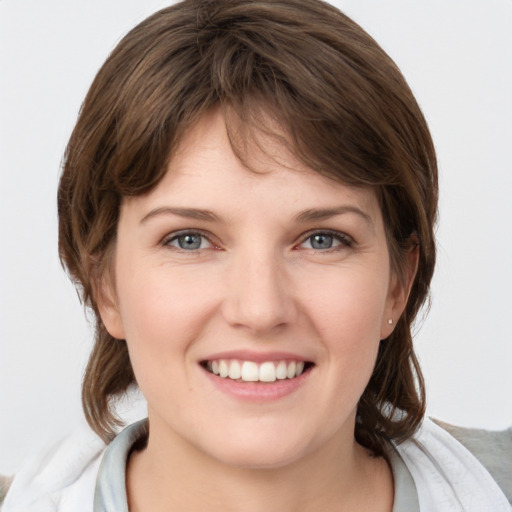 Joyful white young-adult female with medium  brown hair and grey eyes