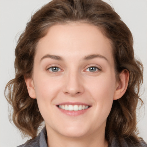 Joyful white young-adult female with medium  brown hair and blue eyes