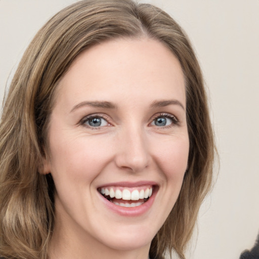 Joyful white young-adult female with medium  brown hair and green eyes