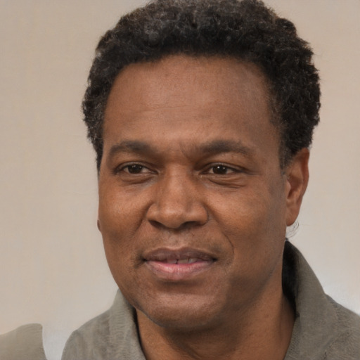 Joyful black adult male with short  black hair and brown eyes
