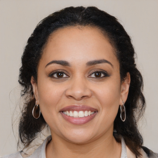 Joyful latino young-adult female with medium  brown hair and brown eyes