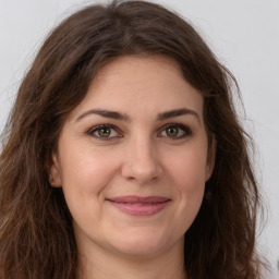 Joyful white young-adult female with long  brown hair and green eyes