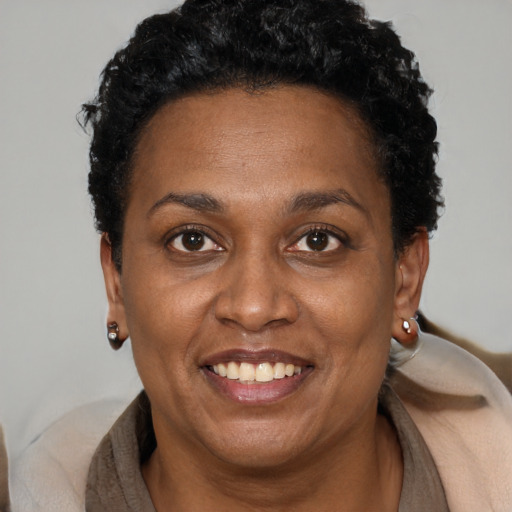 Joyful black adult female with short  black hair and brown eyes