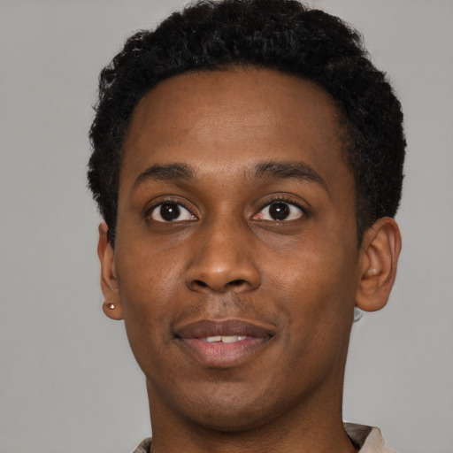 Joyful black young-adult male with short  brown hair and brown eyes