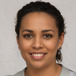 Joyful latino young-adult female with long  brown hair and brown eyes