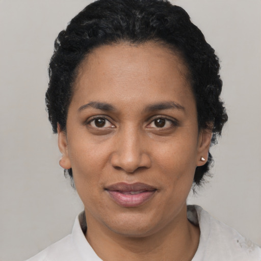 Joyful black adult female with short  black hair and brown eyes