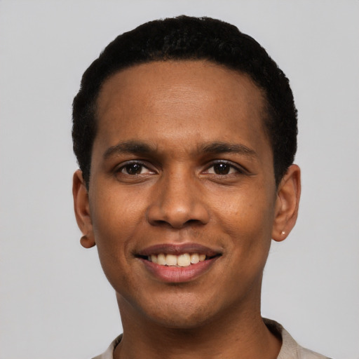 Joyful black young-adult male with short  black hair and brown eyes